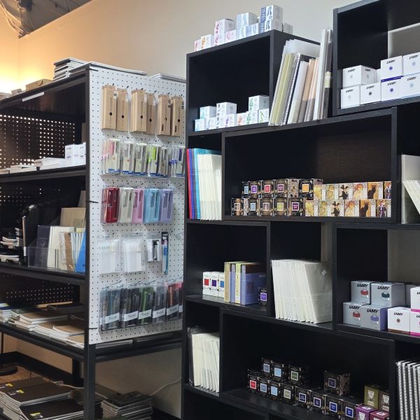 View inside The Gentleman Stationer shop of bottled fountain pen inks and cartridges, notebooks in many sizes and bindings, paper samplers, dip pens, fountain pens, fiber tip pens, etc.